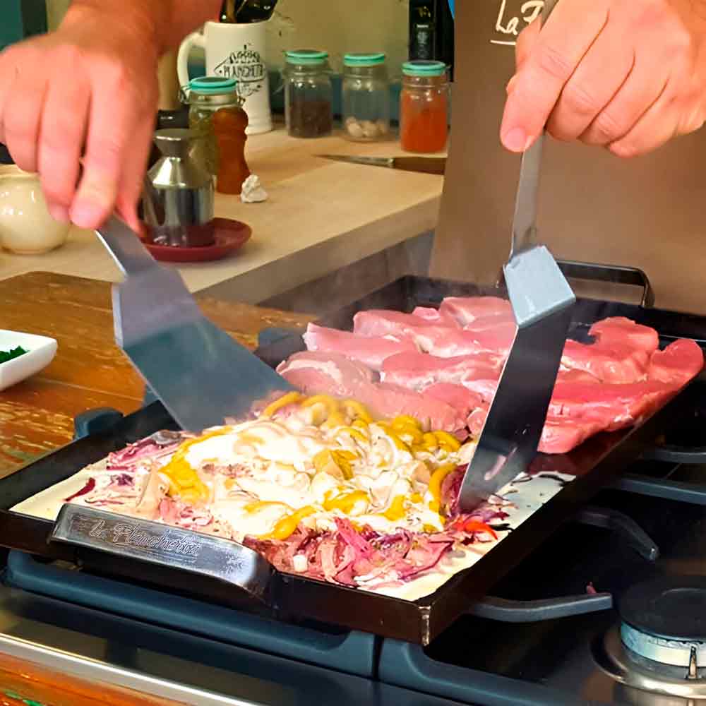 planchetta de 2 hornallas y 2 espatulas con comida en coccion